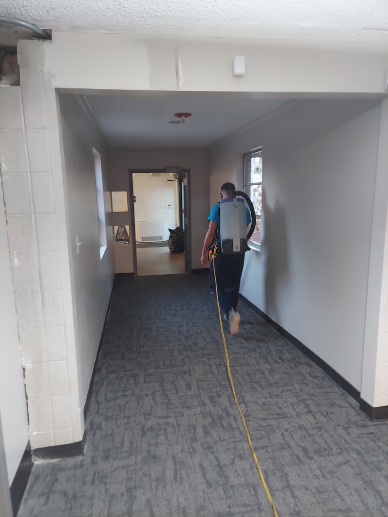 Franco's technician vacuuming a commercial corridor with a backpack vacuum