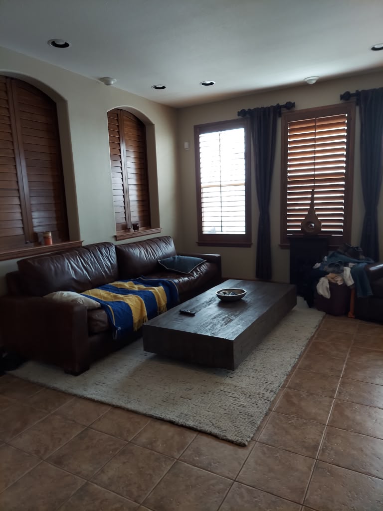 Tidied family room with vacuumed rug and cleaned tile floors