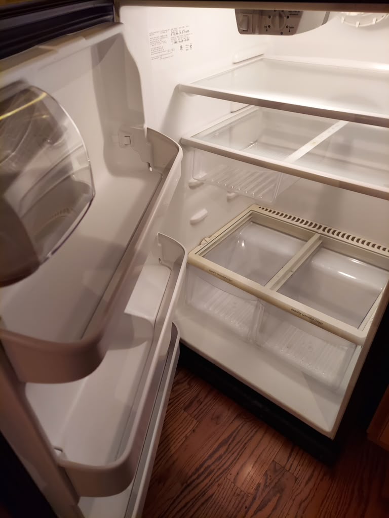 Refrigerator interior after Franco's deep clean, shelves and drawers spotless