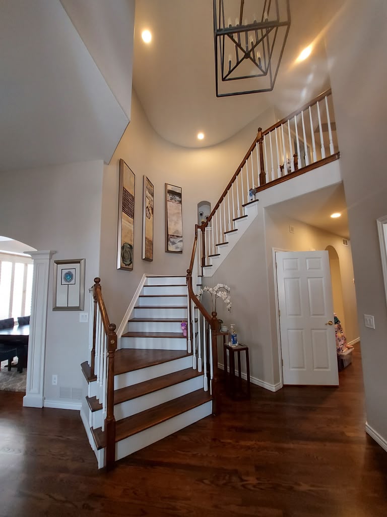 Home entryway and staircase with dusted railings and clean hardwood floors