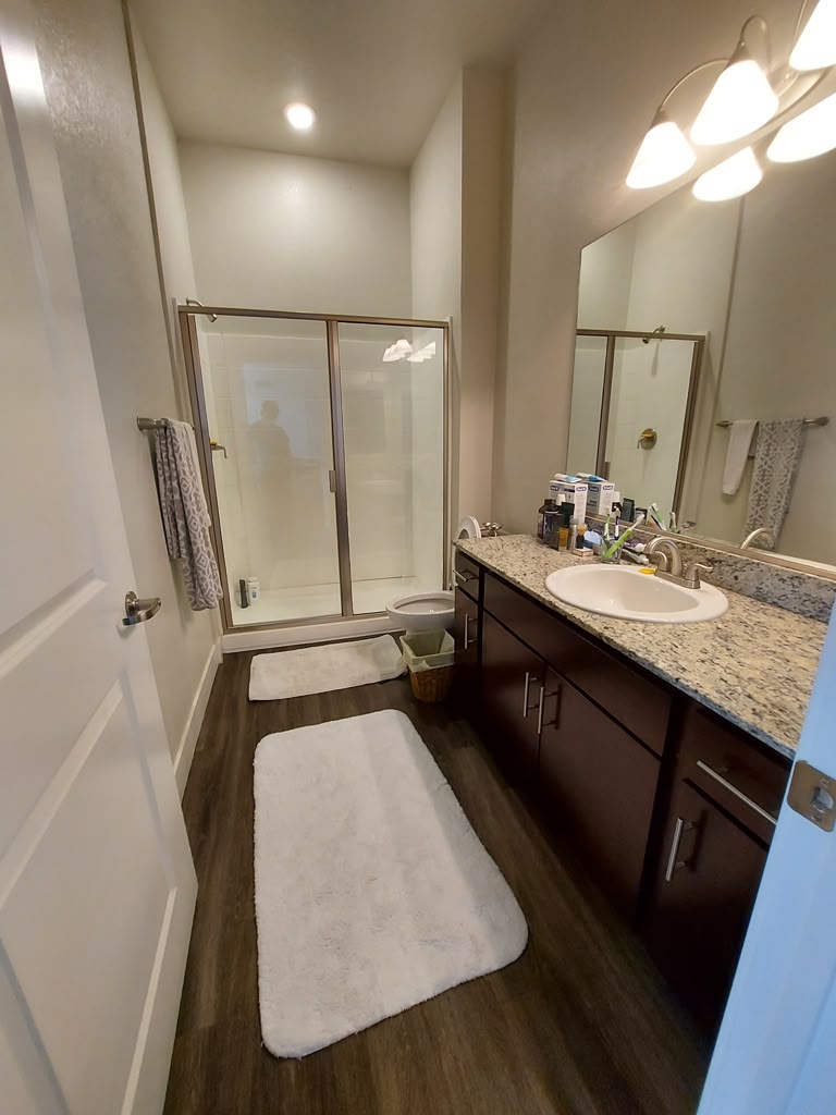 Clean residential bathroom with spotless shower glass, vanity and floors